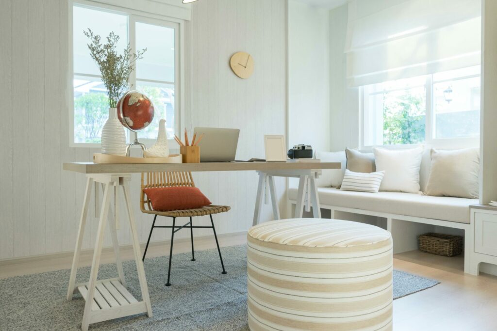 Home office space with white and cream colored walls and furniture.
