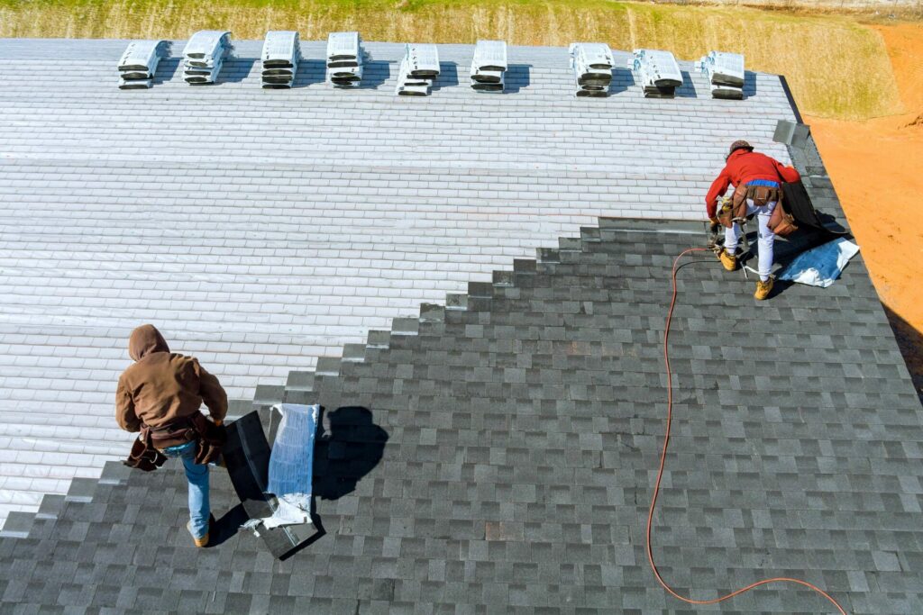 Workers installing a composite roof on a house.